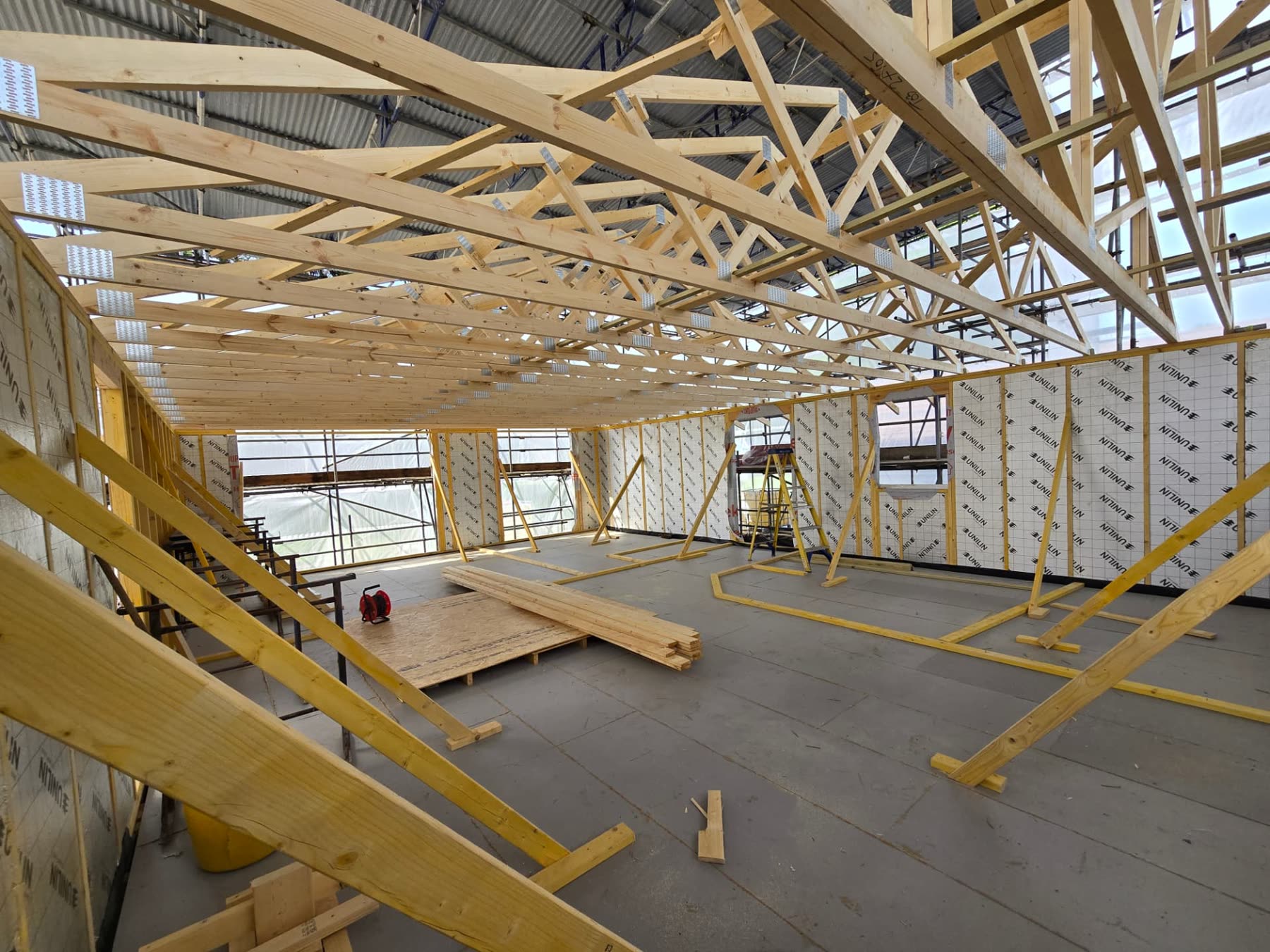 Roof trusses set on insulated blockwork walls during the structural stage of a new build