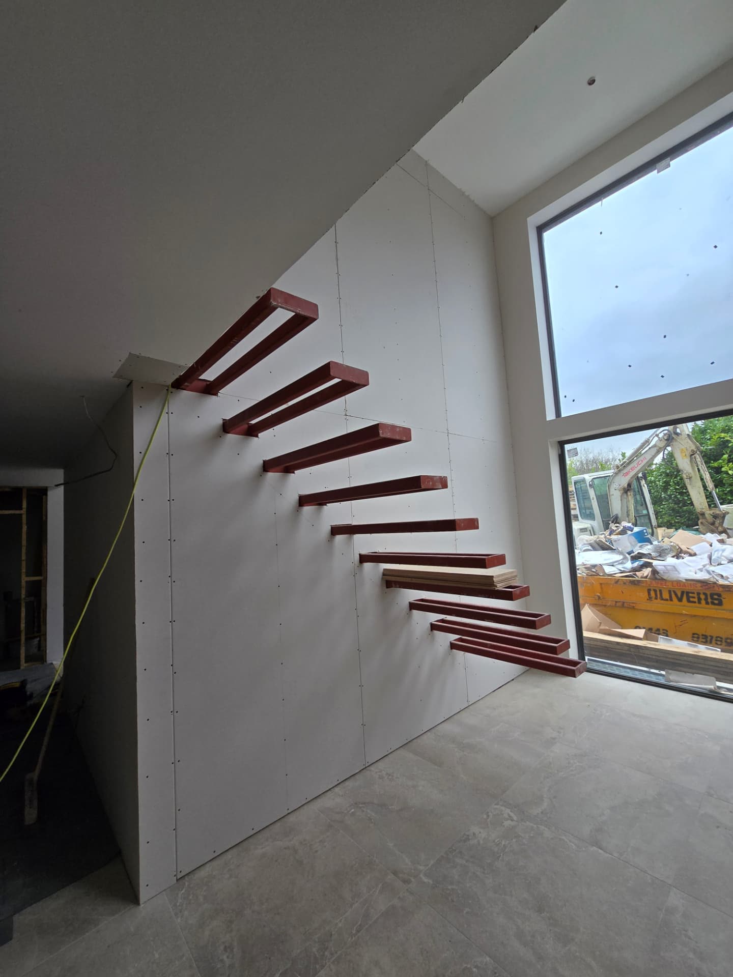 Structural steel staircase stringers fixed in place during first-fix construction