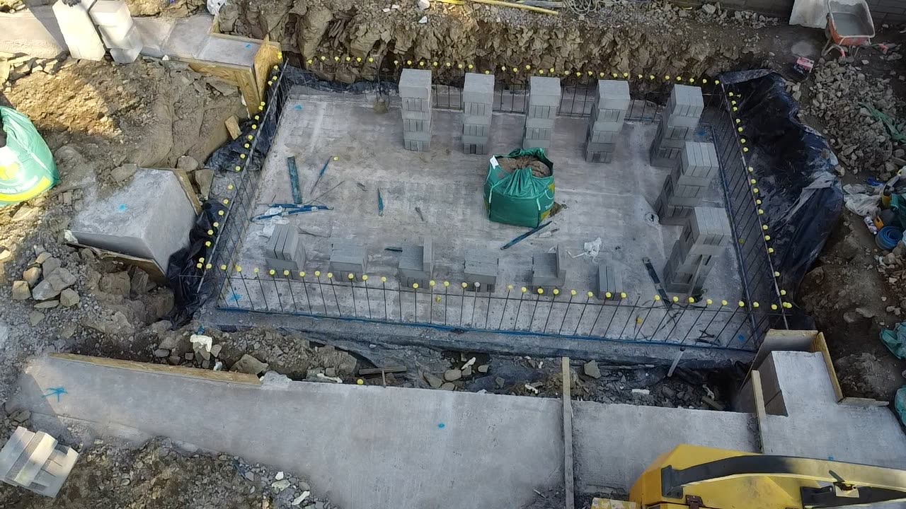 Aerial view of a reinforced concrete swimming pool shell with blockwork steps and rebar cage