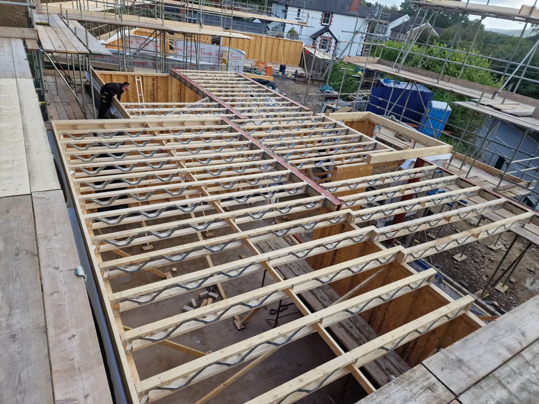 Engineered timber floor joists under construction on a scaffolded new build