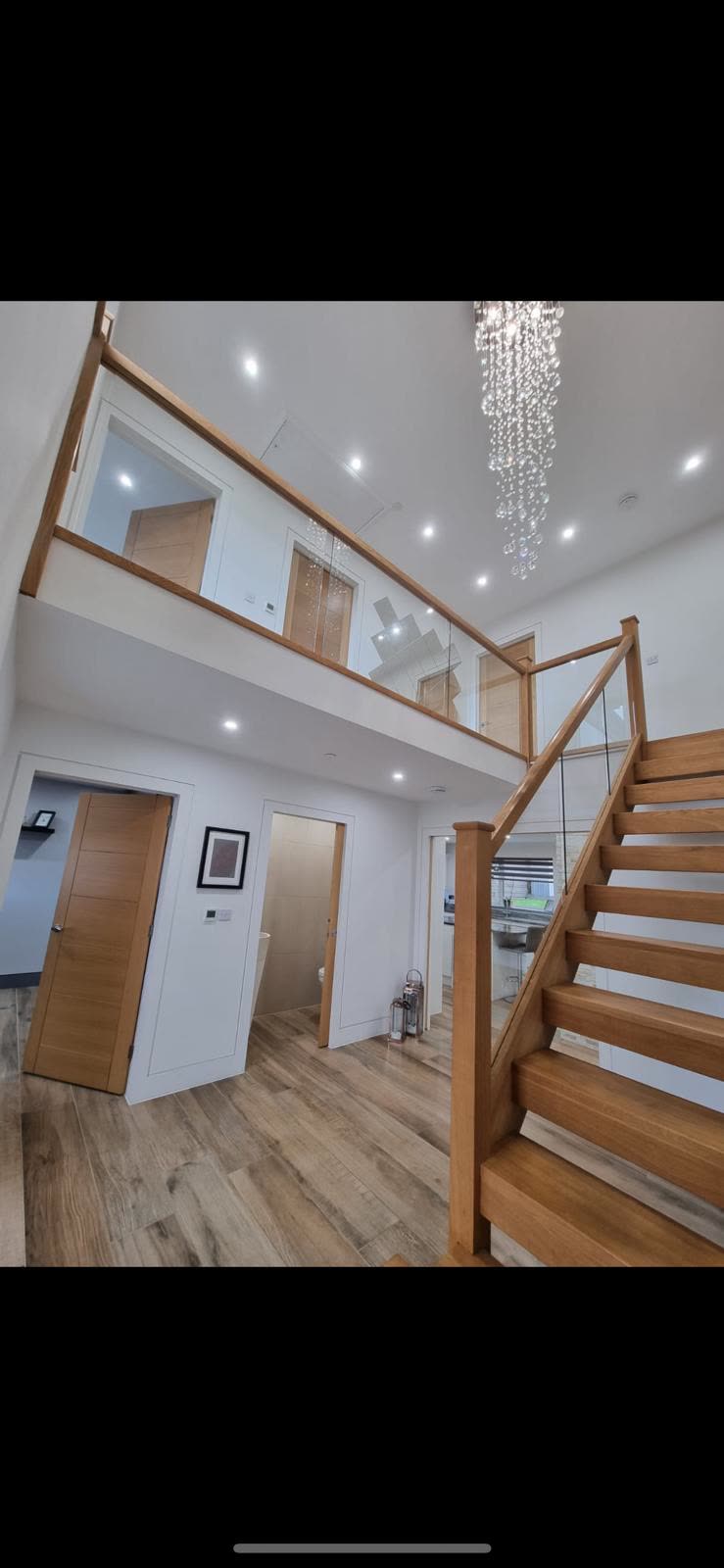 Bespoke home entrance hall with oak staircase and microcement floor