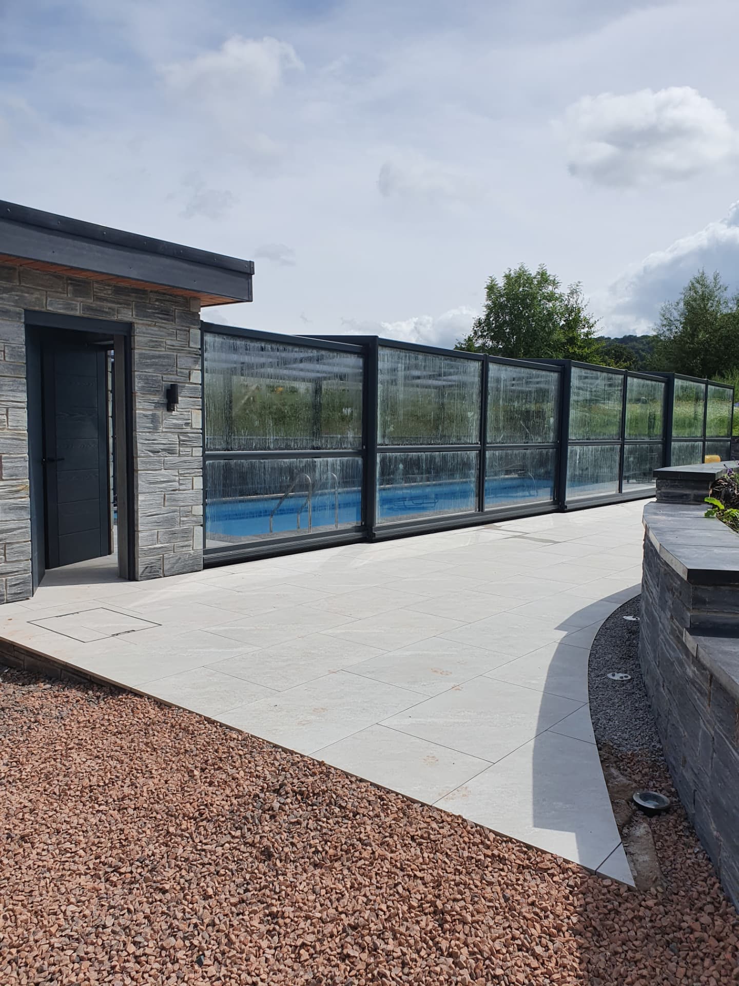 Finished paved terrace walkway alongside a completed swimming pool