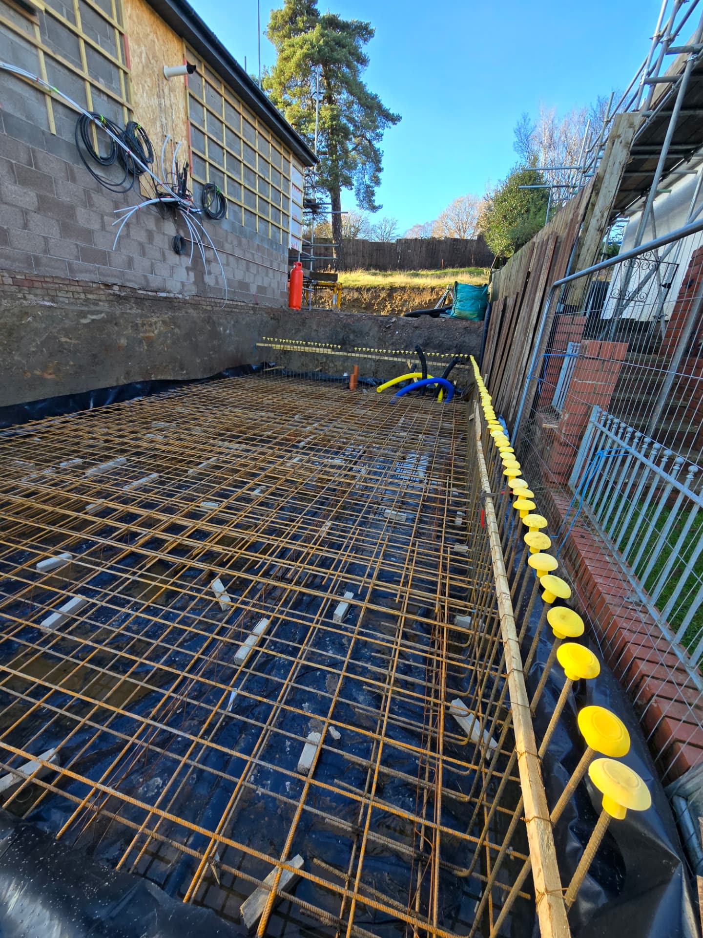 Rebar reinforcement mesh laid over a damp-proof membrane for a swimming pool base