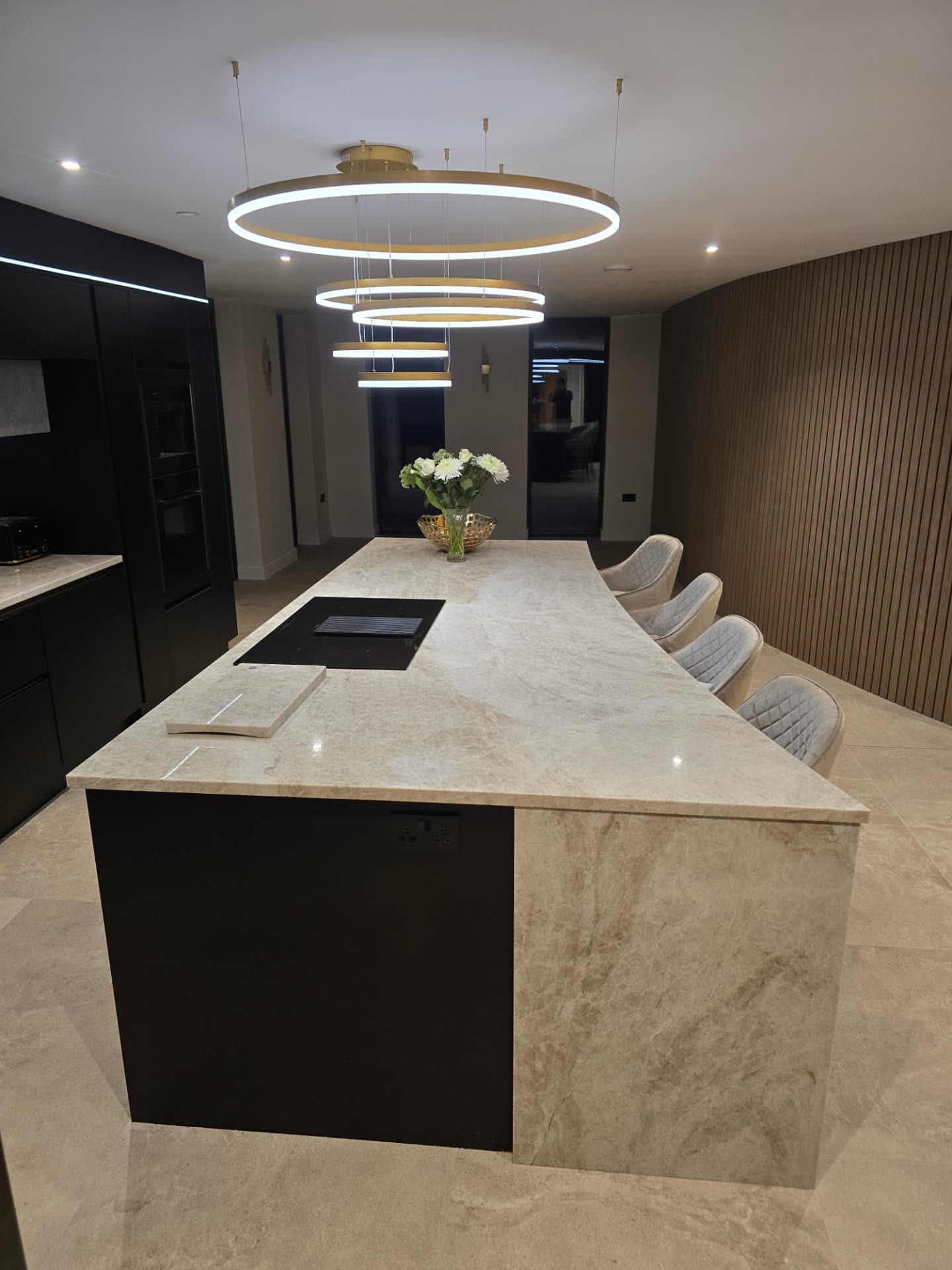 Kitchen island with marble worktop, bar stools and circular brass ring pendant lights